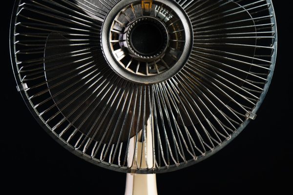 Closeup shot of  a white desk fan on a wooden  table